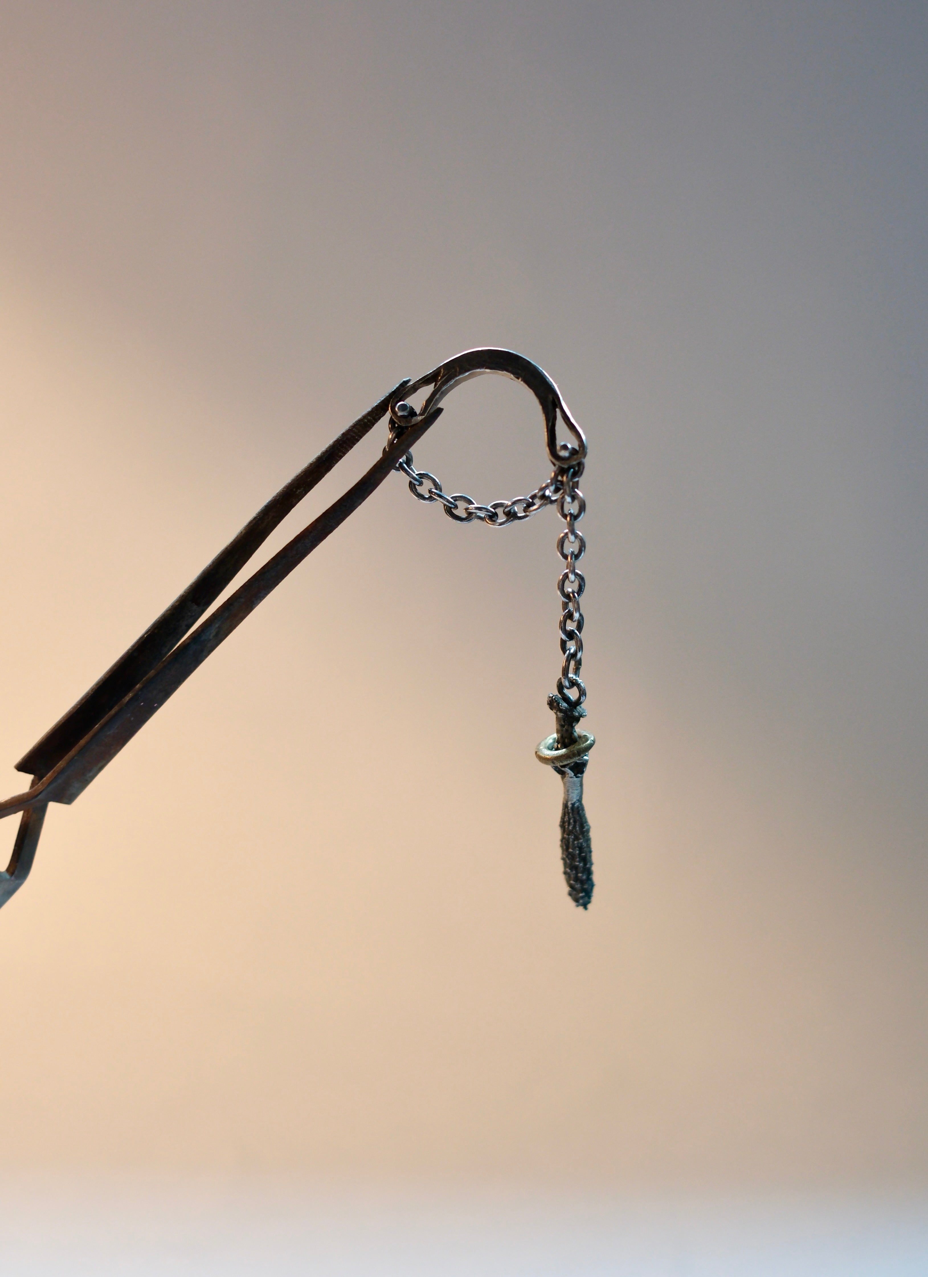 Ring with a long chaim and a charm
